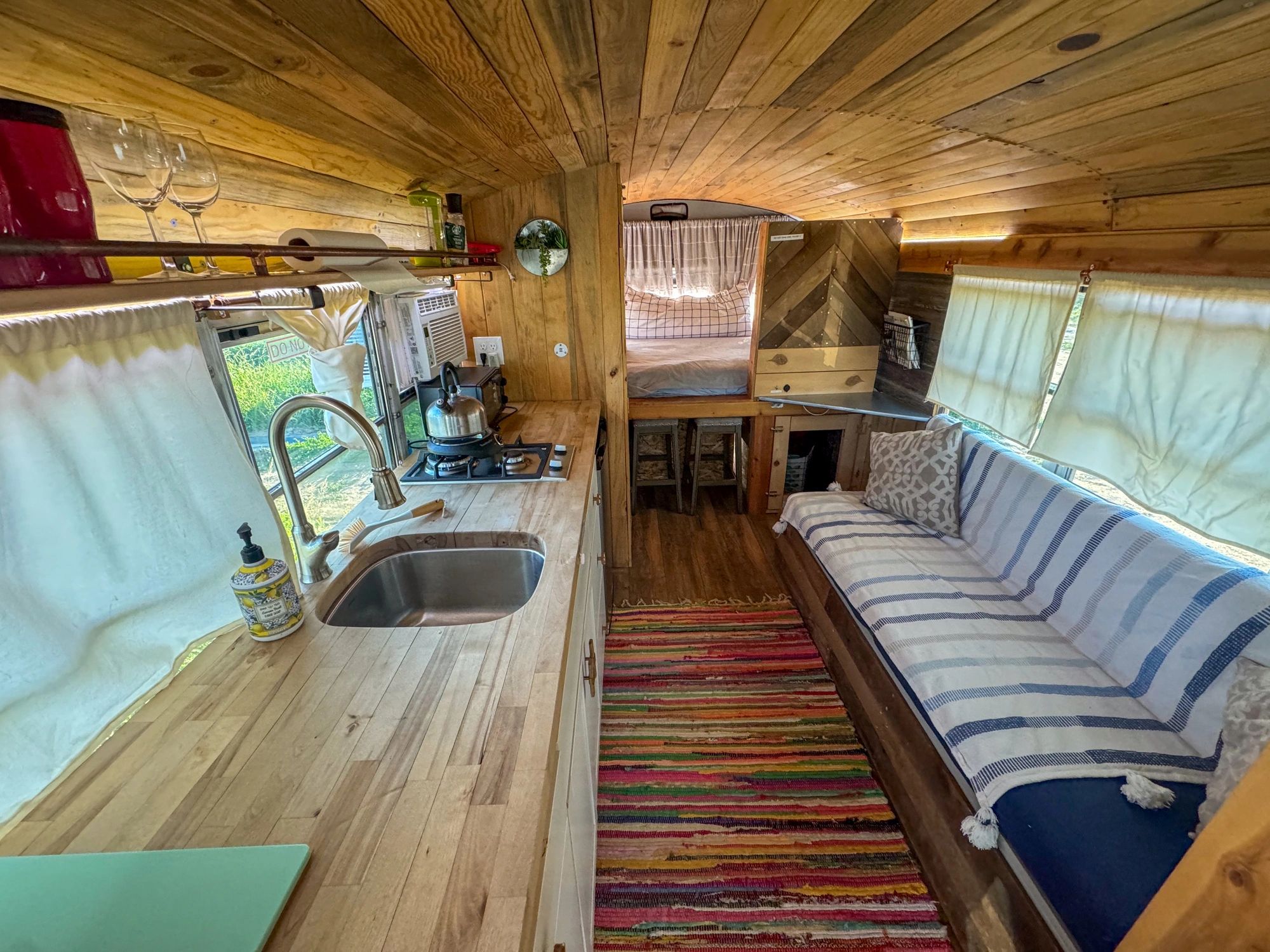 Handcrafted camper interior with wood finishes and compact kitchen