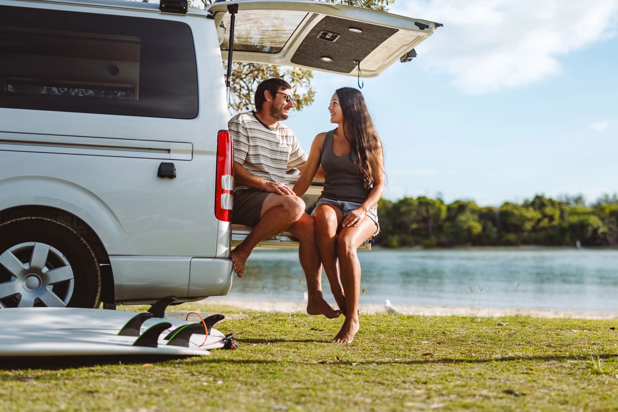 Travelers relaxing beside a camper van during a scenic trip